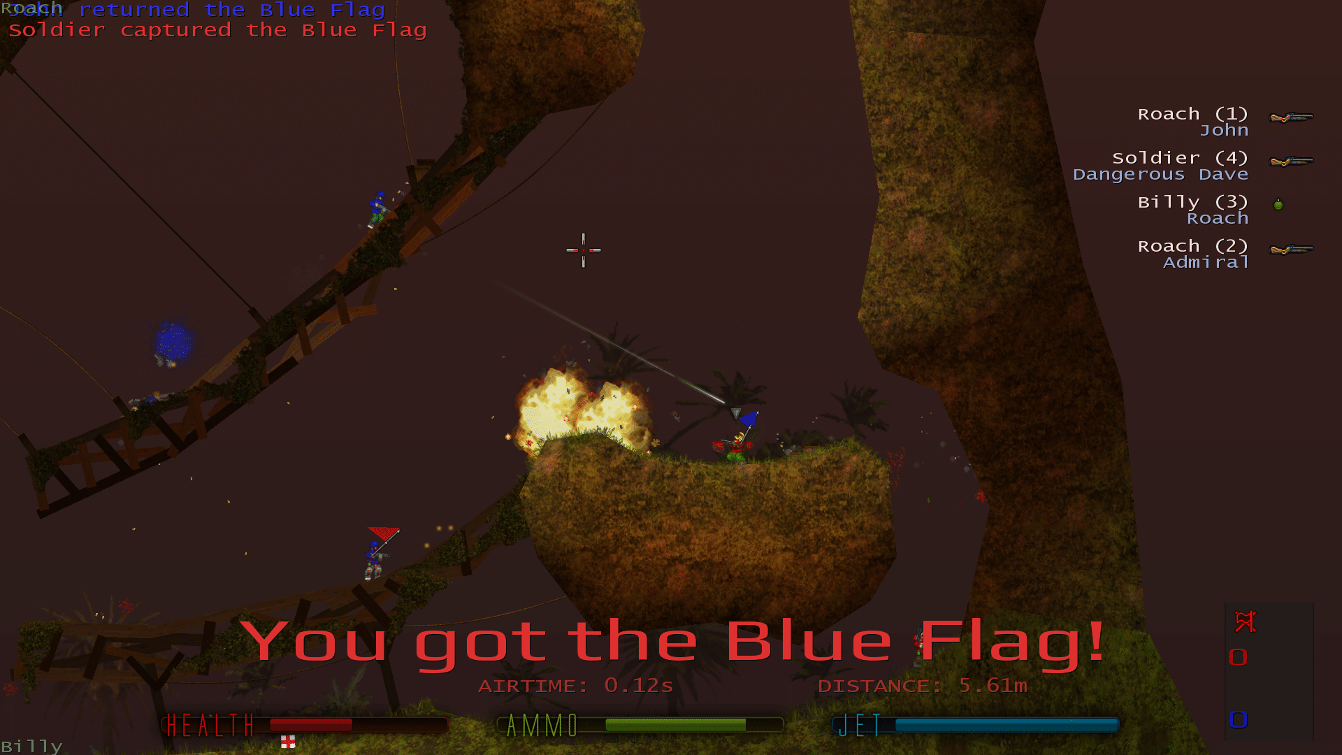 2D-gameplay fra Soldat, hvor en spiller bærer den blå flag på et skovlignende map. Eksplosioner lyser området op, mens flere spillere kæmper på træbroer og klippeformationer. HUD’en viser health, ammo og jet-fuel nederst, og scoreboardet ses til højre.