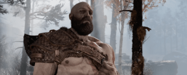 Nærbillede af Kratos i en tåget skov, hvor den arrede kriger står med sin rustning og sit alvorlige blik i God of War.