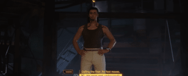 Dialogscene fra Cyberpunk 2077, hvor spilleren taler med en karakter i et mørkt, futuristisk rum, mens spillets gule samtalevalg vises nederst på skærmen.