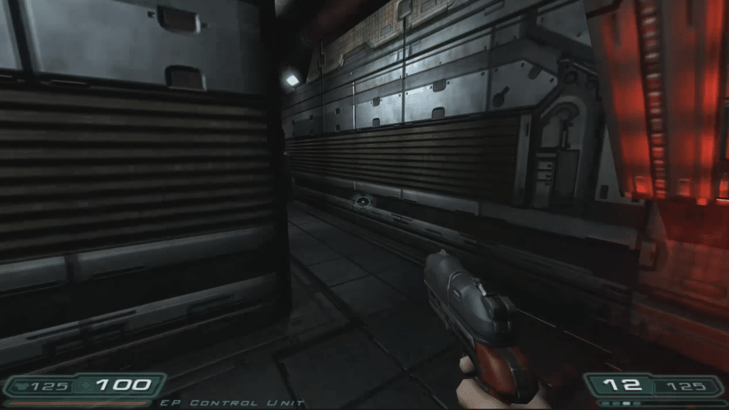 Doom 3 -kuvakaappaus testistämme: pistooli kädessä pimeässä, metallipintaisessa käytävässä Marsin tukikohdassa