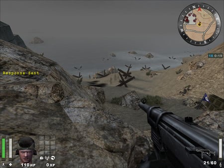 Skærmbillede fra Return to Castle Wolfenstein: Enemy Territory, hvor spilleren ser ud over en strand med forhindringer og fjender i det fjerne, mens en maskinpistol sigtes mod landskabet