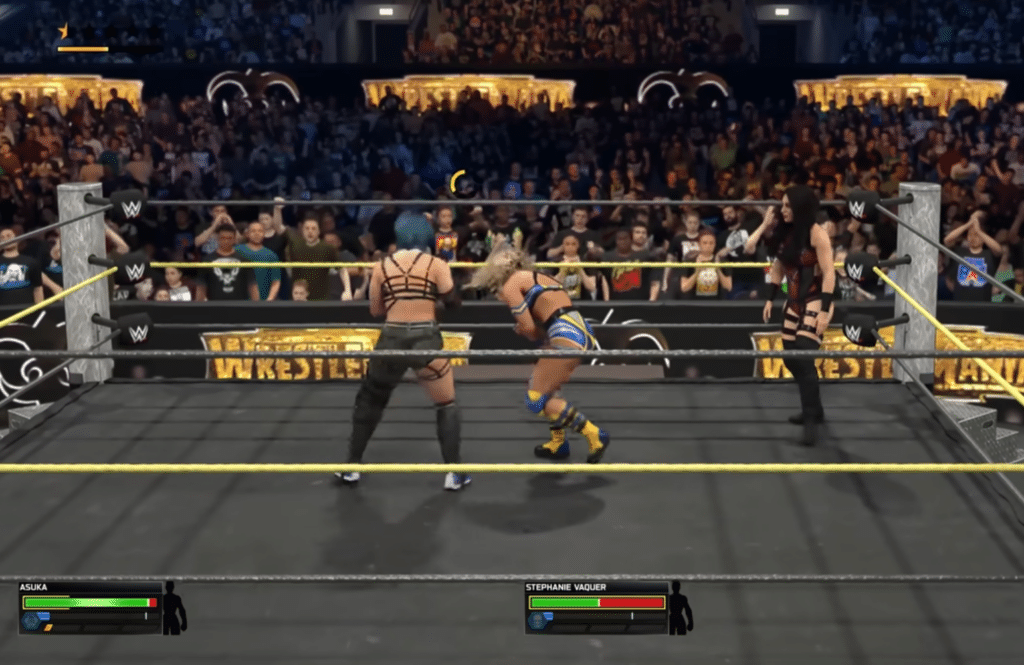 WWE 2K26 gameplay med kvindelige wrestlere i ringen under en intens kamp foran et stort publikum.
