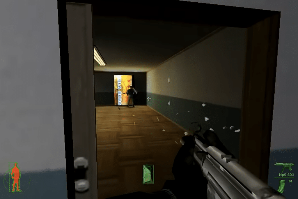 Gameplay-scene fra Project IGI hvor spilleren sigter med et MP5-våben ned ad en korridor mod en bevæbnet fjende under en infiltration i en militærbase