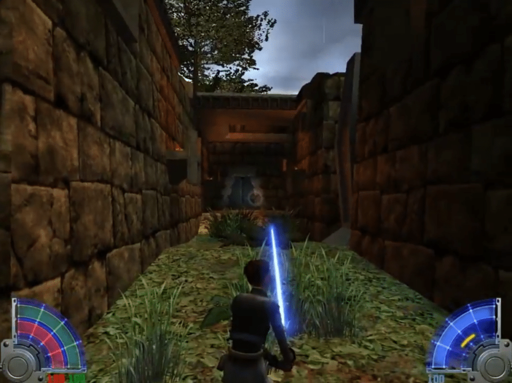 Gameplay i Star Wars Jedi Knight: Jedi Academy, hvor spilleren udforsker en smal ruinbane med et blåt lyssværd klar til kamp.