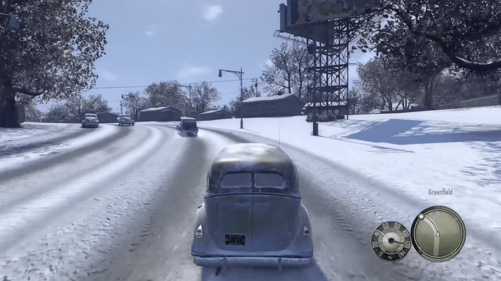 Screenshot fra Mafia 2, hvor Vito kører gennem det sneklædte Greenfield i en klassisk bil.