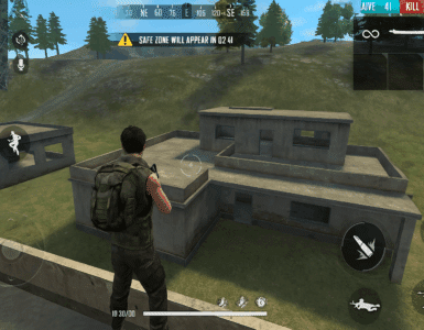 Et screenshot fra Garena Free Fire, hvor en spiller står på taget af en bygning med udsigt til en anden tom bygning i et grønt landskab. Spillets HUD viser kort, antal spillere tilbage og kontrolknapper på skærmen.