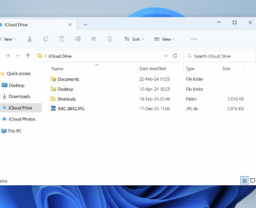 Screenshot af Windows 11 Stifinder med iCloud Drive åbent. I venstre menu ses iCloud Drive og iCloud Photos, mens hovedvinduet viser mapperne Documents, Desktop, Shortcuts samt billedfilen IMG_0842.JPG, som er synkroniseret fra iPhone.