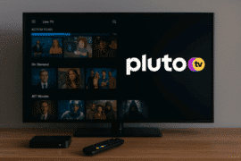 Realistisk foto af et moderne TV i stue, der viser Pluto TV-interface med film og serier på skærmen.