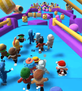 Skærmbillede fra Stumble Guys, hvor flere farverige figurer løber mod målstregen på en forhindringsbane med bevægelige platforme og kanoner i baggrunden.