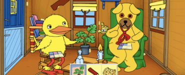 Bamse og Kylling sidder i Bamsegaden og løser en opgave i Bamse – Spil og Leg, omgivet af farverige genstande som planter, honningkrukke og brødkurv.