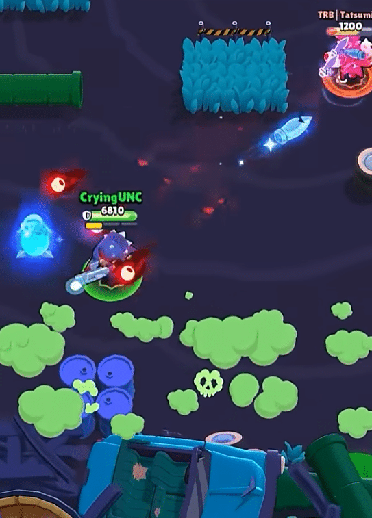Brawl Stars gameplay showing an intense battle as a brawler attacks enemies in a dark arena with bushes, projectiles, and special effects.