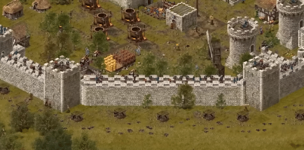Screenshot fra Stronghold: Definitive Edition, hvor en stor middelalderborg forsvares af bueskytter og soldater på murene.