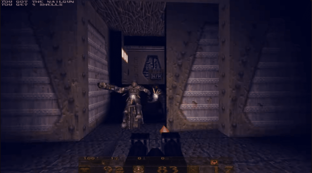 Quake-Gameplay mit Nailgun in einem dunklen Korridor, in dem der Spieler gegen einen bewaffneten Feind kämpft.